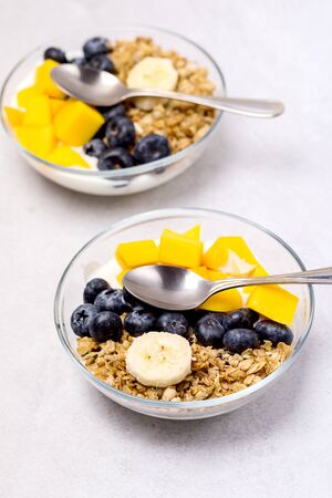 Bowls of Muesl and Yogurt with Berry and Mango Healthy Breakfast Diet Food Copy Spaceの写真素材