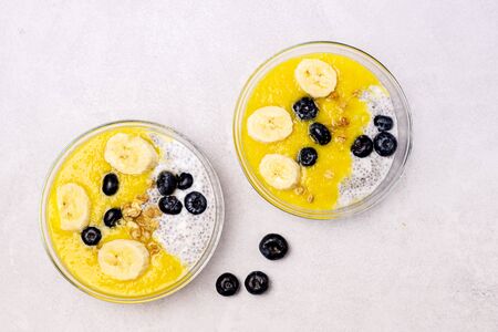 Glass Bowls of Chia Coconut Pudding with Mango Berry and Banana Healthy Vegan Dessert Top Viewの写真素材