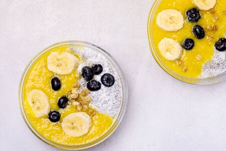 Glass Bowls of Chia Coconut Pudding with Mango Berry and Banana Healthy Vegan Dessert Top Viewの写真素材
