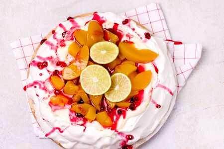 Pavlova Meringue Cake Decorated With Peach Berry Jam and Lime Tasty Homemade Summer Dessert Horizontal Top Viewの写真素材