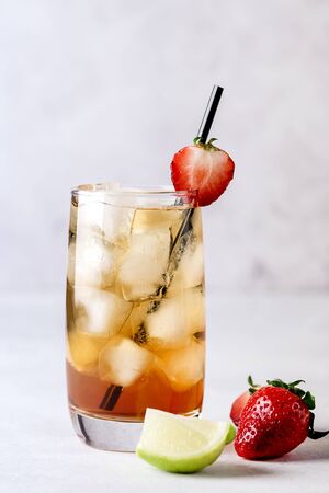 Glasses of Cold Citrus and Strawberry Ice Tea on Light Gray Background Decorated with Ripe Lime and Strawberry Healthy Symmer Beverage Refreshing Drink Verticalの写真素材