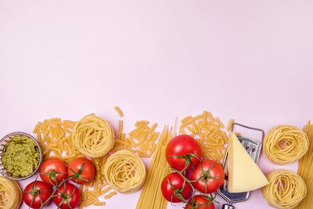 Dry Pasta Spaghetti Tagliatelle Fusilli Raw Vegetables Tomato Parmesan Pesto in Glass Bowl Horizontal Copy Space Italian Foodの写真素材