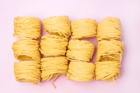 Group of Italian Egg Pasta Nest Tagliatelle Pink Background Italian Food Top Viewの写真素材