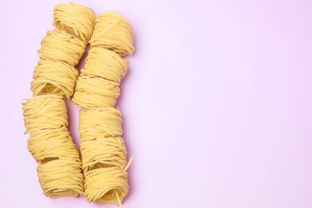 Group of Italian Egg Pasta Nest Tagliatelle Pink Background Italian Food Top View Copy Spaceの写真素材