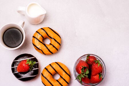 Chocolate and Orange Donuts with Fresh Strawberries and Cup of Coffee Cream Top View Flat Lay Copy Space Breakfast Concept Morningの写真素材