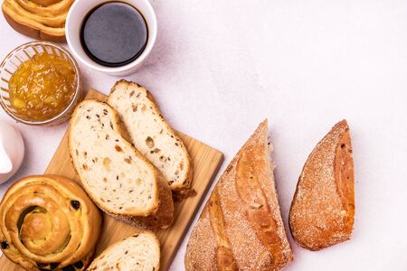 Tasty Breakfast Freshly Baked Buns with Raisins and Cinnamon Fresh Homemade Bread Cup of Black Coffee Orange Jam in Glass Bowl Top View Copy Spaceの写真素材