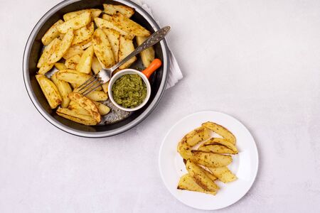 Roasted or Baked Potatoes With Spice in Black Bowl on Light Gray Background Tasty Homemade Dish Dinner Grilled Potatoes Top View Horizontalの写真素材