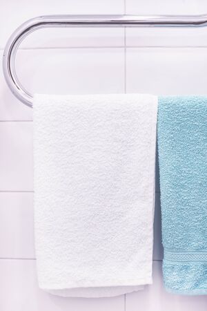 White and Green Towels hangs Hang and Dries on the Batteries in Bathroom Verticalの写真素材