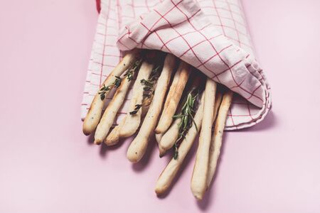 Homemade Cheese or Bread Sticks with Herds Crispy Bread Sticks with Thyme and Rosemary on Pink...