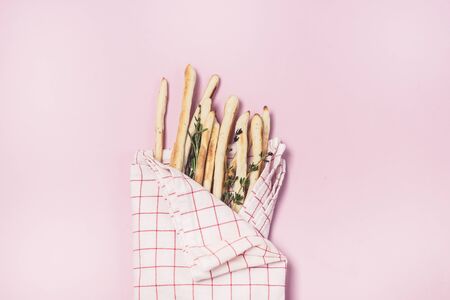 Homemade Cheese or Bread Sticks with Herds Crispy Bread Sticks with Thyme and Rosemary on Pink Background Top View Horizontalの写真素材