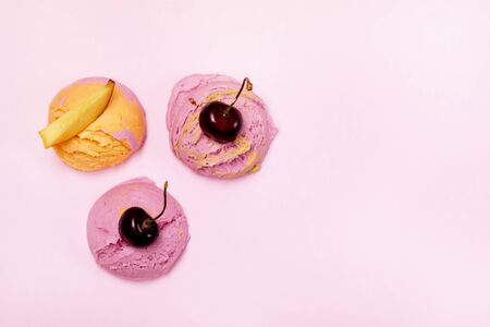 Set of three Various Ice Cream Balls or Scoops Decorated with Fruits on Pink Background Top View Peach and Cherry Flavor Copy Spaceの写真素材