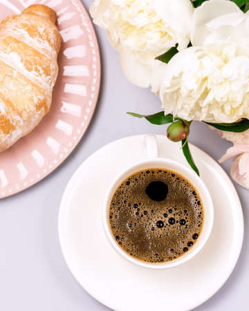 Still life with Cup of Coffee Croissants and Peonies Flowers Breakfast Morning Verticalの写真素材