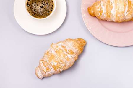 Two Fresh and Tasty Croissants and Cup of Coffee Blue Background Top View Horizontalの写真素材