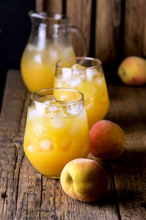 Ripe Peaches Tasty and Cold Peaches Juice Healthy Drink with Ice Cube Gray Background Horizontalの写真素材