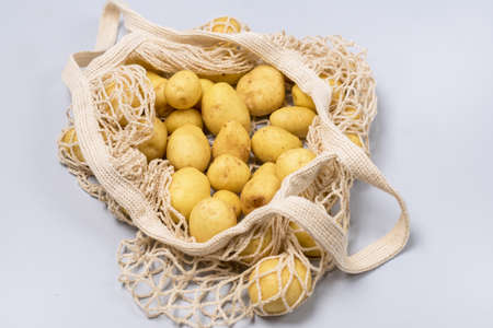 Eco Bag with Raw Young Potatoes on Blue Background Top View Horizontalの写真素材