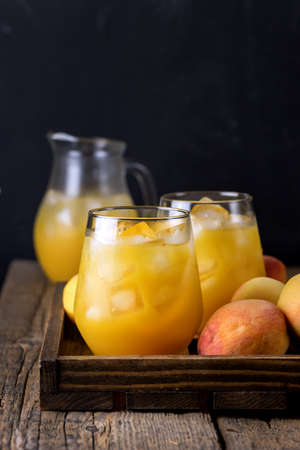Ripe Peaches Tasty and Cold Peaches Juice Healthy Drink with Ice Cube Old Wooden Background Vertical Dark Photoの写真素材