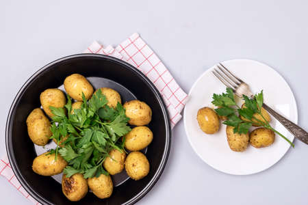 Two Plate of Organic Young Roasted Potatoes Decorated with Parsley Blue Background Top Viewの写真素材
