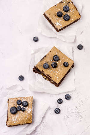 Pieces of Homemade Chocolate Brownies Decorated with Ripe Blueberry on Gray Background Tasty Chocolate Dessert Top Viewの写真素材