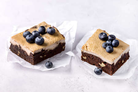 Pieces of Homemade Chocolate Brownies Decorated with Ripe Blueberry on Gray Background Tasty Chocolate Dessert Copy Spaceの写真素材