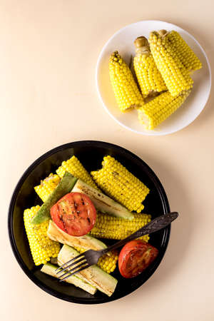 Black Plate of Grilled Vegetable Zucchini, Corn, Tomato Tasty and Healthy Diet Food Yellow...
