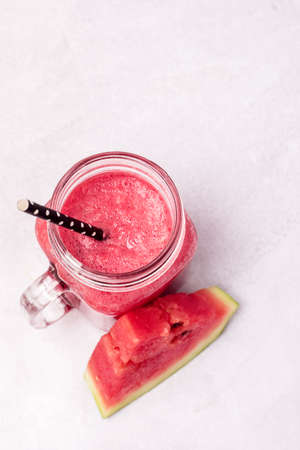 Glass Jar of Tasty Watermelon Smoothie on Blue Background Vertical Healthy and Tasty Summer Drinkの写真素材