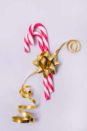 Two Candy Canes with Gold Ribbon on Blue Background Vertical Holiday Backgroundの写真素材