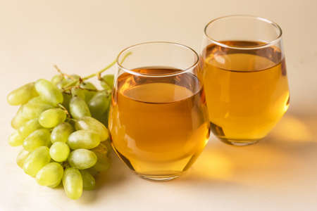 Two Glasses of Tasty Grape Juice on Yellow Background Healthy Drink Raw Green Grape Horizontalの写真素材