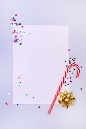 Christmas or New Year Mock Up or Background with Copy Space Candy Cane and Confetti Flat Lay Top View Vertical Blue Backgroundの写真素材