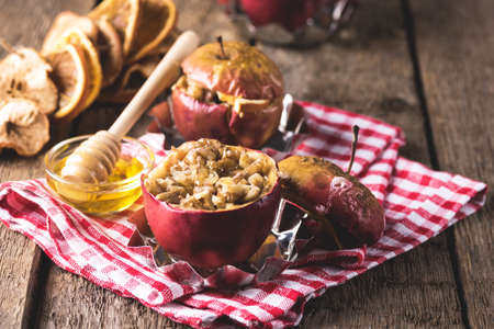 Tasty Homemade Baked Apple with Cinnamone Honey and Huts Healthy Seasonal Autumn or Winter Dessert Wooden Background Horizontalの写真素材
