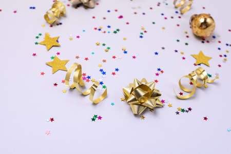 Confetti in Shape of Stars Gold Ribbons Gold Christmas Balls on Blue Background Festive Holiday Card...