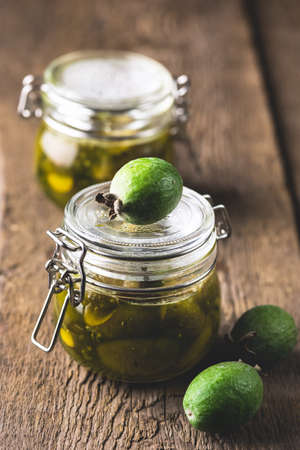 Glass Jars of Tasty Homemade Feijoa Jam on Wooden Background Vertical Dessertの写真素材
