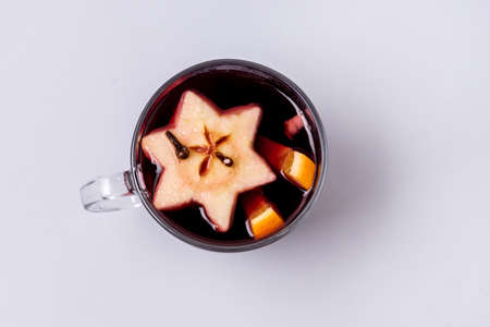Glass Mug of Delicious Mulled Wine with Orange Apple and Spices Christmas Beverage Blue Background Top Viewの写真素材