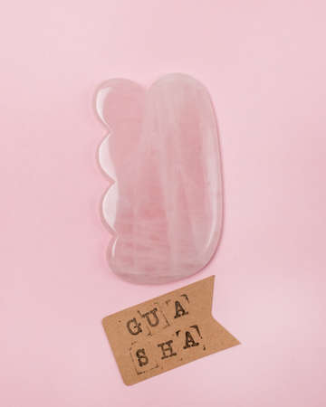 Facial and Body Stone Massage Instruments Gua Sha Lifting Skin Massage Pink Background Top View