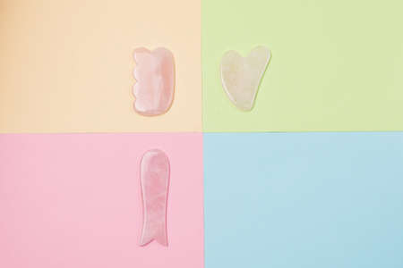 Gua Sha Massagers on Colored Background Pink jade stone for face and body Horizontal Flat lay Top view Copy Spaceの写真素材