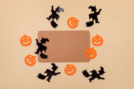 Halloween Holiday Background with Confetti in Shape of Witches and Pumpkin Yellow Background Copy Spaceの写真素材