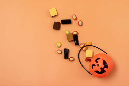 Small Jack-O-Lantern Pumpkin Basket with Candy Orange Background Copy Space Top Viewの写真素材