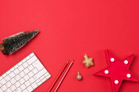 Christmas Holiday Theme White Computer Keyboard Red and Gold Christmas Decoration Red Pencils Holiday Bussines or Blogger Background Red Backgroud Top Viewの写真素材