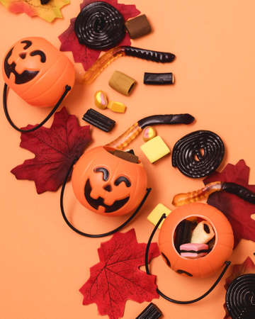 Halloween Background Spooky Halloween Candy and Sweets on Orange Background Small Jack-O-Lantern...