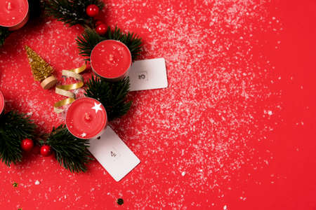 Nice Advent Wreath Red Candles Golden Christmas Ornaments on Red Background Snow Holiday Minimal Concept Top View Copy Spaceの写真素材