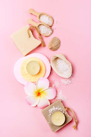 Sea Salt Aroma Candles Face Sponges Plumeria Flower Small Bamboo Scoops with Salt Natural Soap Pink Background SPA Vertical Wellnessの写真素材