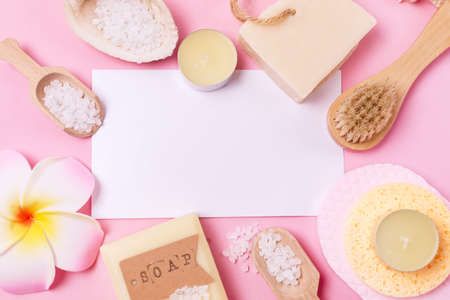 Sea Salt Aroma Candles Face Sponges and Bamboo Face Brush Plumeria Flower Natural Soap Pink Background Copy Space SPA Frame Top View Horizontal Wellnessの写真素材