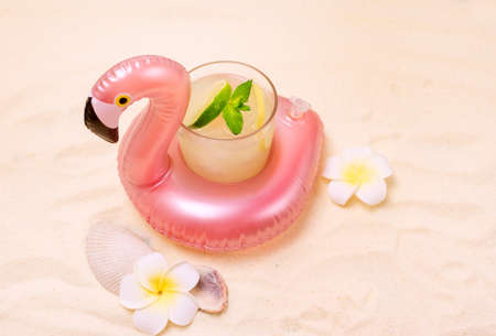Inflatable Flamingo Toy Ring Holders Drinks for Swimming Pool Party with Glass of Cold Cocktail Tropical Horizontalの写真素材