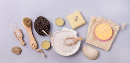 Flay Lay Sea Salt Aroma Candles Face Sponges Bamboo Face Brush Plumeria Flower Natural Soap Scoop with Salt Shell Pumice Pink Background SPA concept Top View Horizontal Wellnessの写真素材