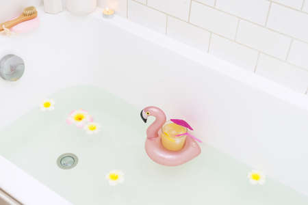 Bathtub with Plumerria Flowers and Inflatable Flamingo Toy Ring with Drink Bamboo Face Brush Home...