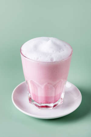 Matcha Red or Pink tea latte in t glass on Green background Healthy Drink Verticalの写真素材