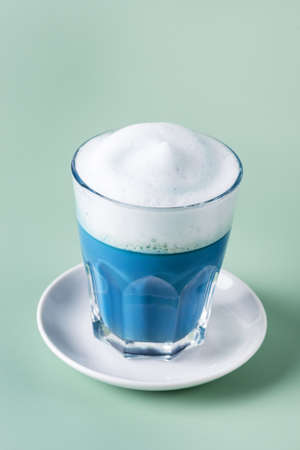 Matcha Blue tea latte in t glass on Green background Healthy Drink Verticalの写真素材