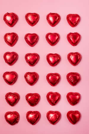 Red heart chocolate candy on Pink Background St Valentine Holiday Background Dessert for Valentine Day Pattern Top Viewの写真素材