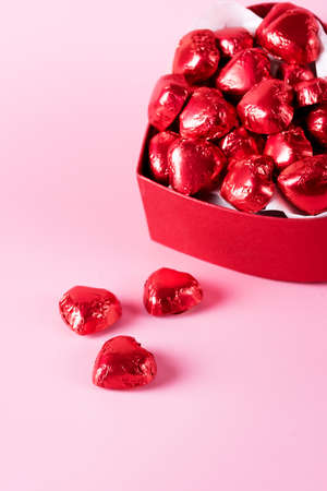 Beautiful Red Chocolate Hearts Candies in Red Box Shape of Heart on Pink Background St Valentine Day Background Dessert Verticalの写真素材