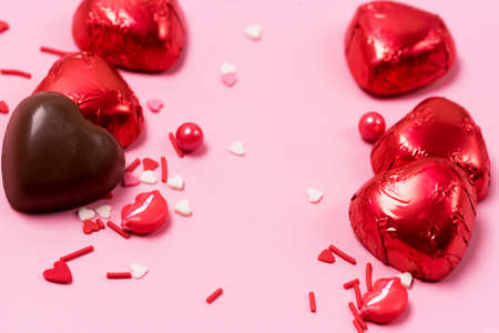 Beautiful Red Chocolate Hearts Candies on Pink Background Valentine Day Holiday Background Vertical Frameの写真素材