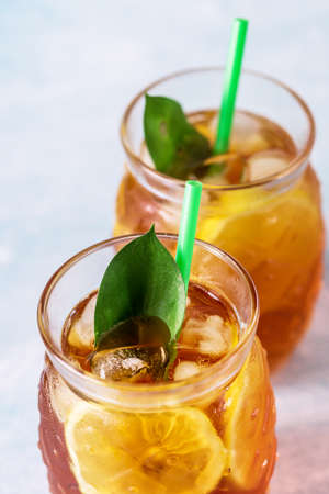 Glass of Delicious Iced Tea with Lemon on Light Blue Background Vertical Above